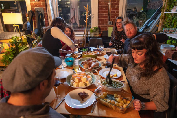 istock Guests Serving Themselves and Each Other at a Friendsgiving Dinner 1439862603