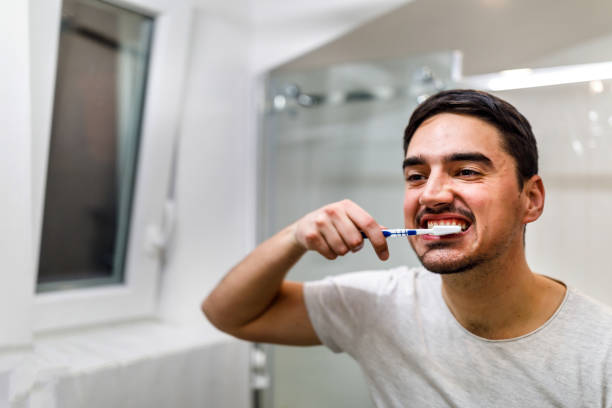 istock A photo of a young man doing his morning routine and brushing his teeth. 1439864462