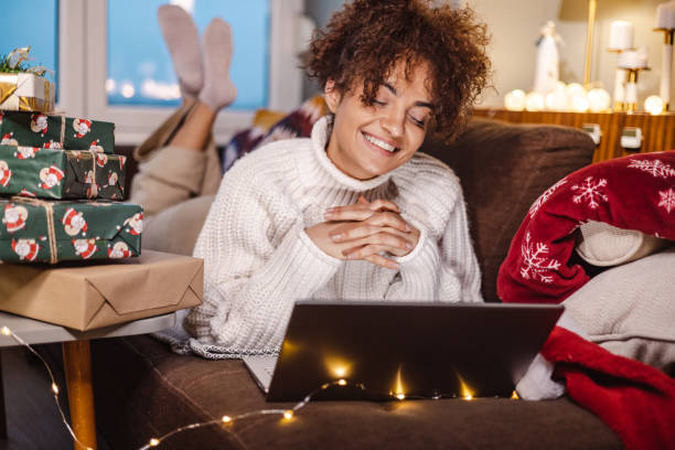 istock Young woman using laptop at night during winter holidays 1439864699