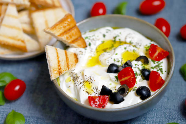 Greek yogurt dip with olives and croutons. stock photo