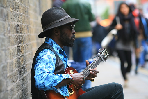 05/11/2014 Male guitarist musician playing guitar in Brick Lane, London UK