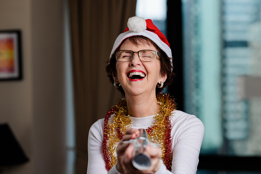 Laughing festive woman with a paper bon bon
