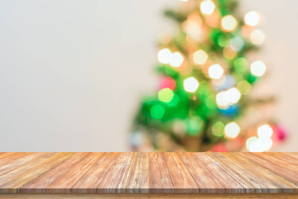 istock Empty wood table top with blur Christmas tree with bokeh light background 1439869531