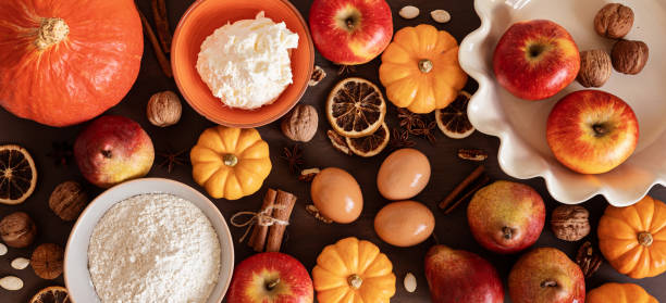 istock Fall pie baking ingredients with pumpkins, apples, pears, nuts, seasonal spices and tools. Cooking pumpkin or apple pie. Thanksgiving and autumn holidays celebration concept 1439869535