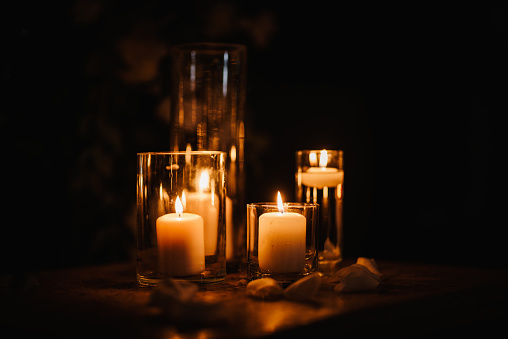 Burning candles over old wooden table with bokeh lights