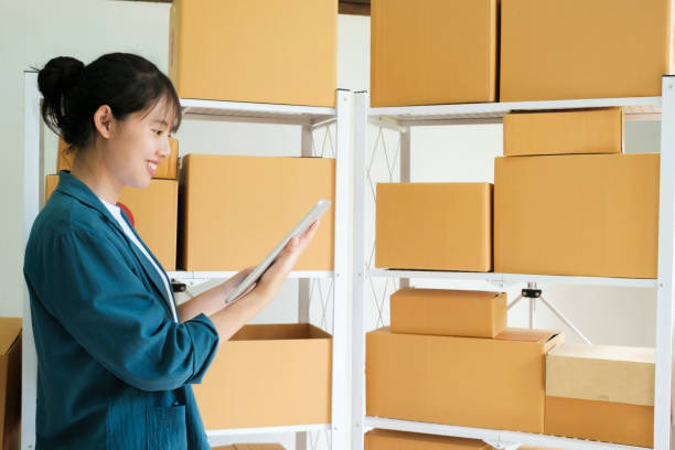 istock Online store owner checking orders for packaged product. 1439872457