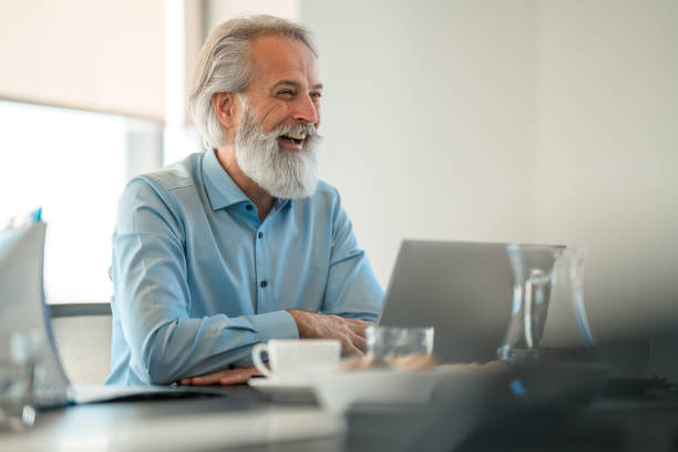 istock Smiling White Business Man Listening to Presentation 1439873456