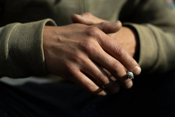 istock Hand in detail. Cigarette sandwiched between packs. 1439877147