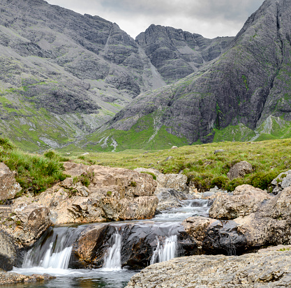 Long line of waterfalls and rocky mountain pools at the foot of the Black Cuillin Mountains,popular tourist site,spectacular Skye scenery,a steep path with boulders and swimming areas.