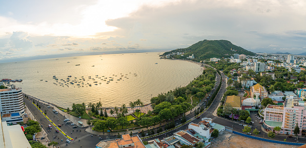 Panoramic coastal Vung Tau view from above, with waves, coastline, streets, coconut trees and Tao Phung mountain in Vietnam