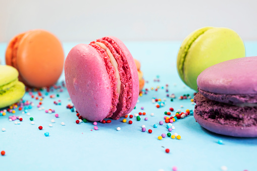 Colorful macaroons on a blue background. Close-up, side view.