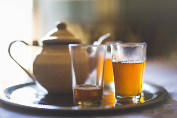 close up of a moroccan tea pot with glasses on a silver plate