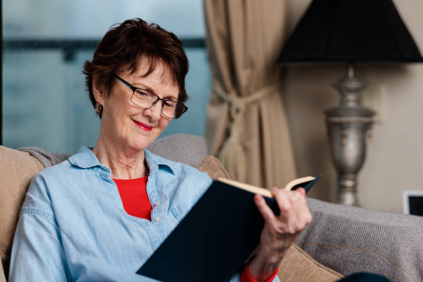 istock Smiling woman reading a book. 1439890941