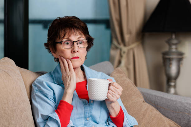 istock Woman with coffee cup sitting down with a blank stare 1439893756