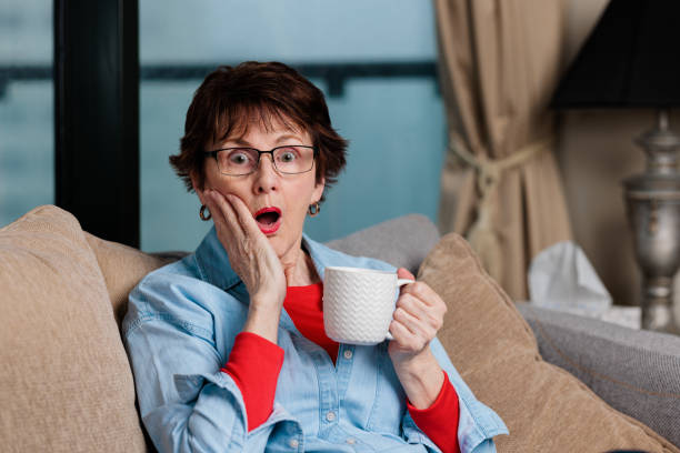 istock Woman with coffee cup sitting down with a suprised expression 1439893770