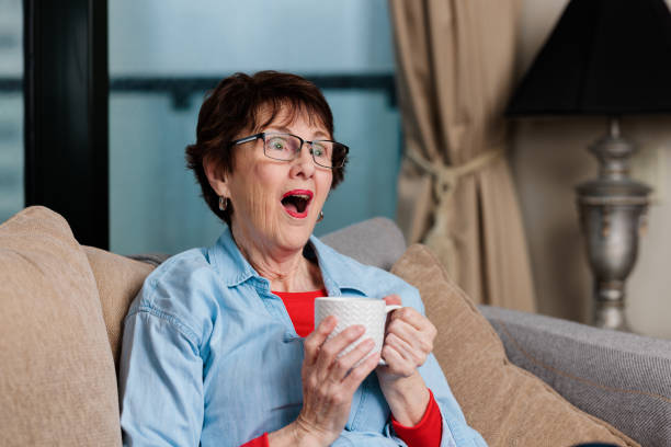 istock Woman with coffee cup sitting down with a suprised expression 1439893854