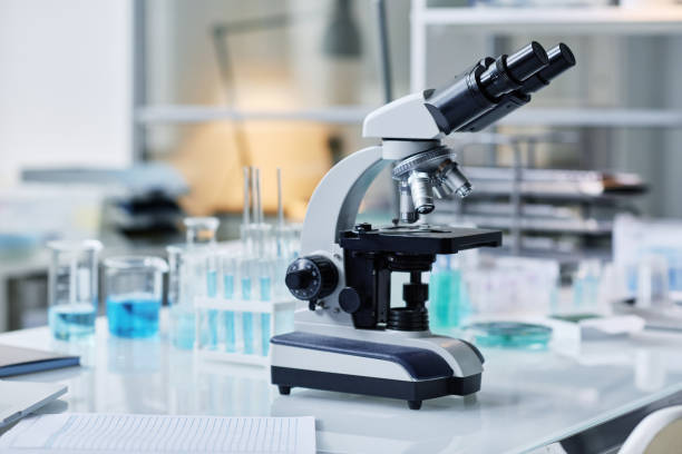 istock Microscope and group of flasks and other glassware on workplace of scientist 1439899832