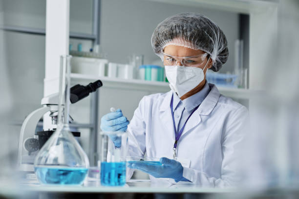 istock Young female researcher in protective workwear making clinical experiment 1439902441