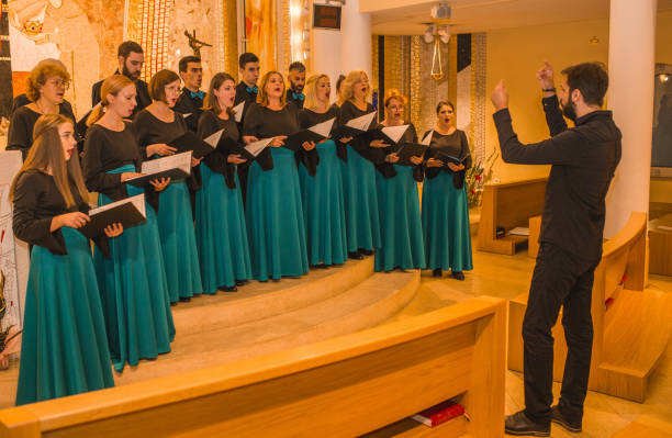 istock A group of people dressed in the same formal clothes rehearse before a choral performance with a musical conductor 1439904654