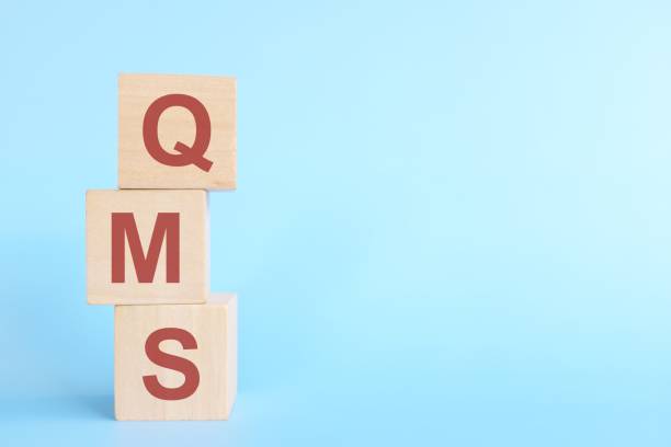 istock QMS or quality management system on wooden blocks in blue background. 1439905007