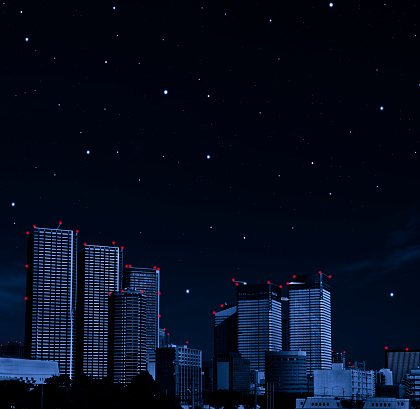 Lots of stars shining in the sky over the skyscrapers with copy space.