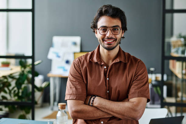 Young successful intern in eyeglasses and brown shirt