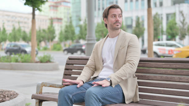 istock Young Man Coming, Sitting on Bench and Checking Time 1439908190