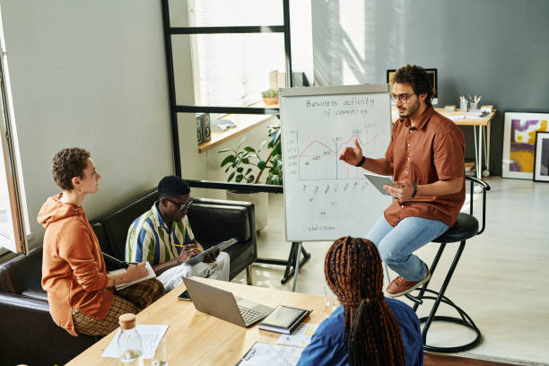 istock Young confident business coach sitting by whiteboard 1439910557