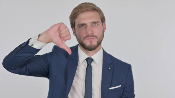 istock Thumbs Down by Young Businessman on White Background 1439911966
