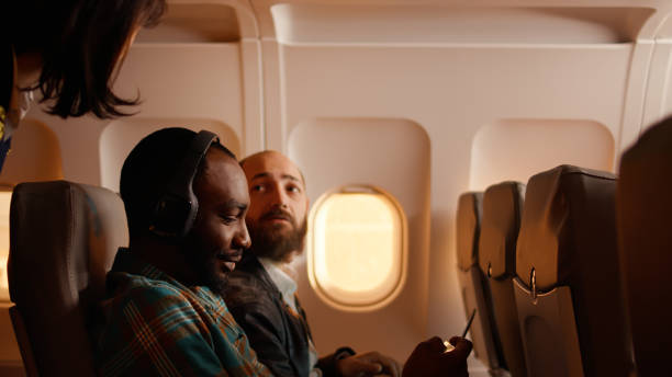 istock Male passenger talking to flight attendant on airplane 1439913503