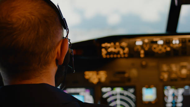 istock Male aviator using handle and windscreen in cockpit to fly airplane 1439914134