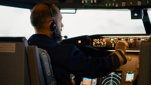 istock Airplane captain pushing buttons to fix altitude and longitude 1439914247