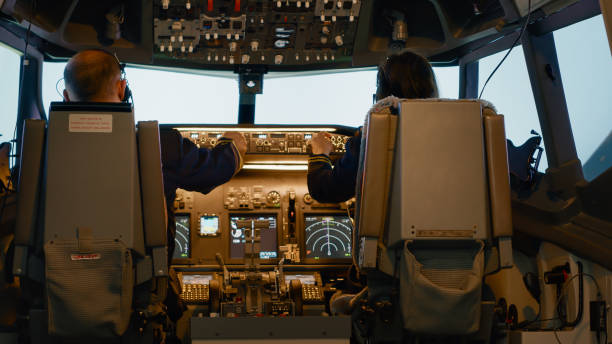 istock Plane captain and woman copilot fixing altitude on dashboard 1439914262