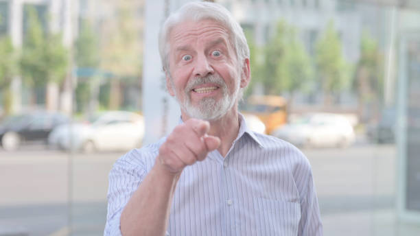 istock Old Man Pointing at the Camera and Inviting Outdoor 1439914277