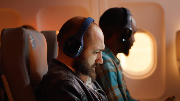 istock Passenger in airplane seat using laptop to work on flight 1439914544