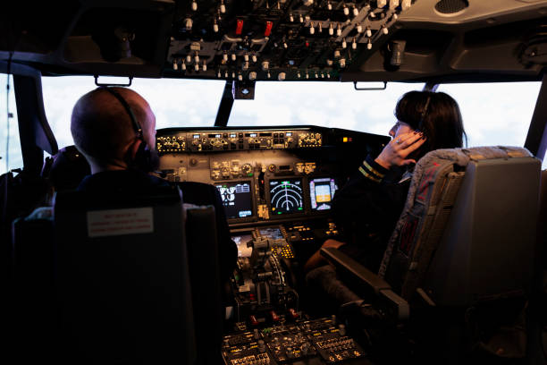 istock Team of airliner and captain using power switch on cabin dashboard 1439915936
