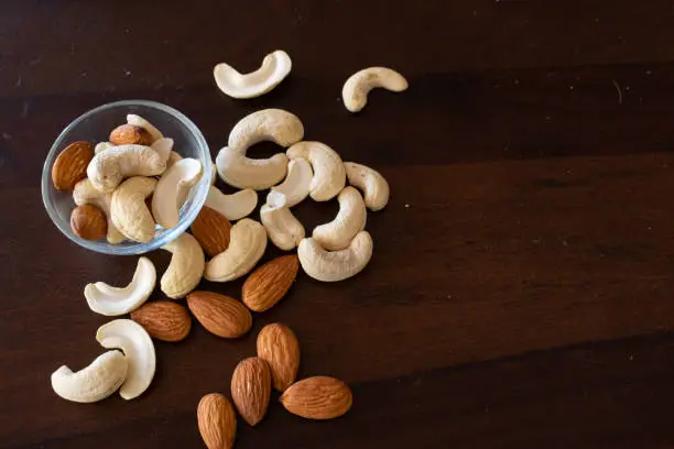 Cashewnuts and almonds arranged on a table in small bowl of glass. Kaju, badam, dry fruits, healthy, cholesterol, sweet, tasty, Diwali, festival, gift, shopping, box, soak, nuts, protein, fats, carbs.