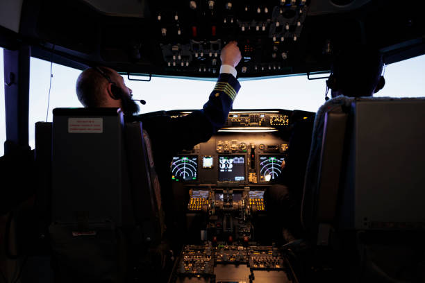 istock Aircraft captain pushing dashboard handle in plane cockpit 1439916250