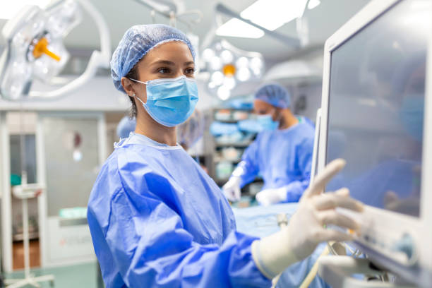 concentrated surgical team operating a patient in an operation theater. well-trained anesthesiologist with years of training with complex machines follows the patient throughout the surgery. - cirurgião imagens e fotografias de stock