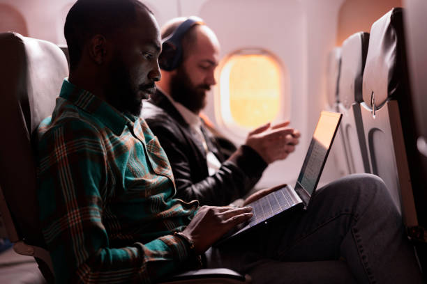 istock African american passenger working on laptop during sunset flight 1439917109