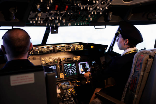 istock Female airliner in uniform flying airplane with cockpit command 1439917150