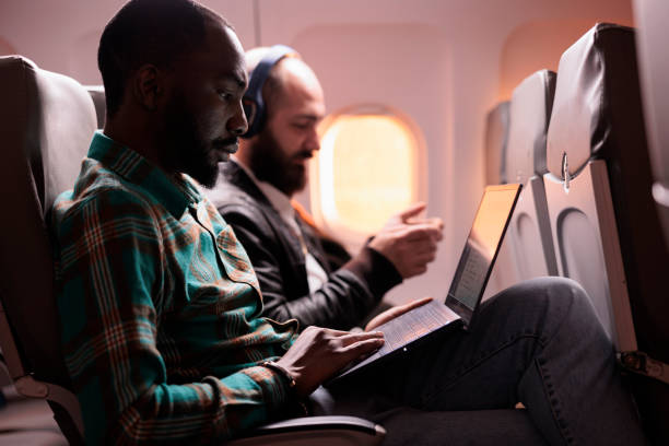 istock Businessman in seat travelling on work trip by airplane 1439917188