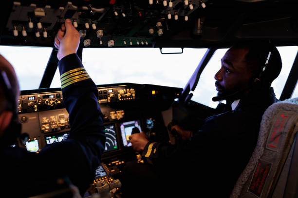 istock Multiethnic team of pilots using control panel in cockpit to fly airplane 1439917215