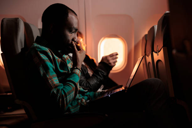 istock African american employee working on laptop during plane flight 1439917232
