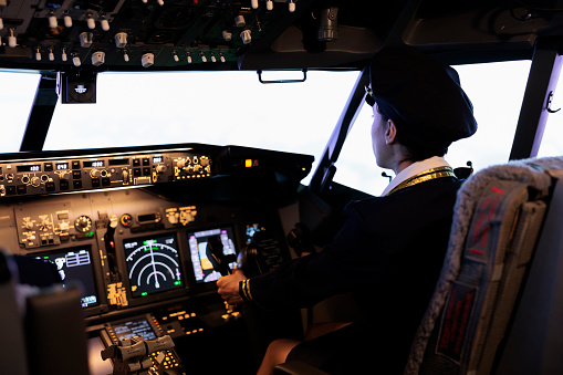 Pilot and co-pilot piloting airplane from airplane cockpit