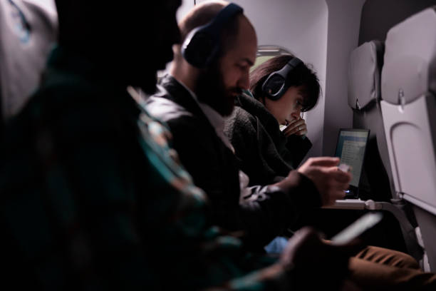 istock Diverse people travelling on airplane and using laptop 1439917337