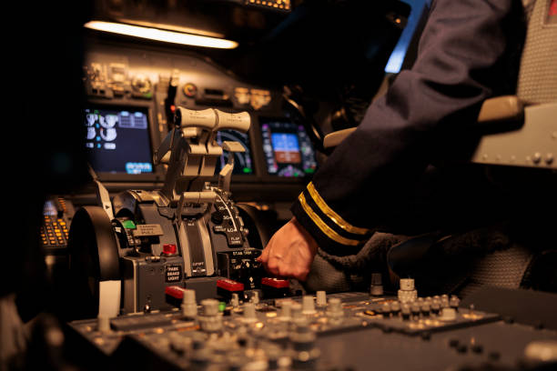 istock Woman airliner pushing dashboard buttons in plane cockpit 1439917399