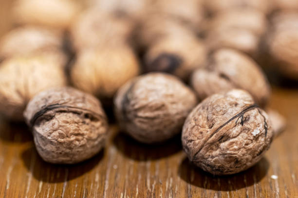 istock Heap of unpeeled walnuts on wooden table 1439917426