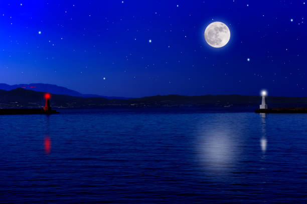 istock Full moon rising over the sea and the lighthouse 1439921752