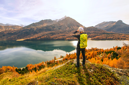 Man observes bewildered autumn landscape in a mountain lake
